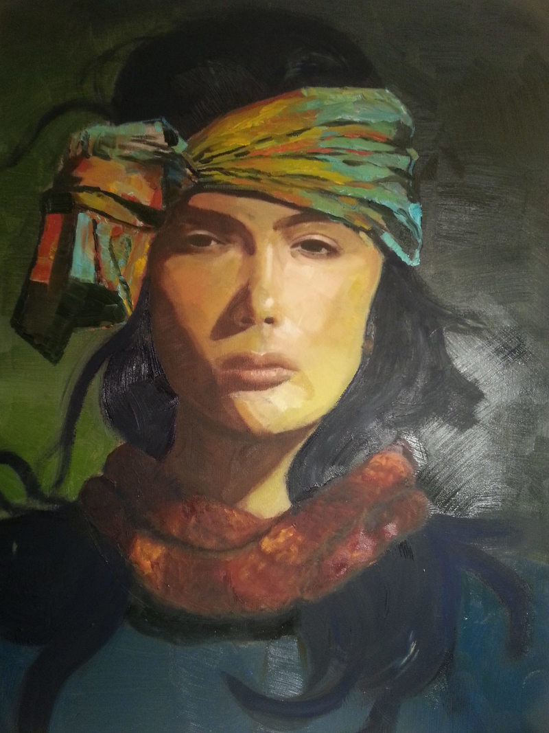 Portrait of a women with a black hair, colorful headscarf, and dark red scarf.